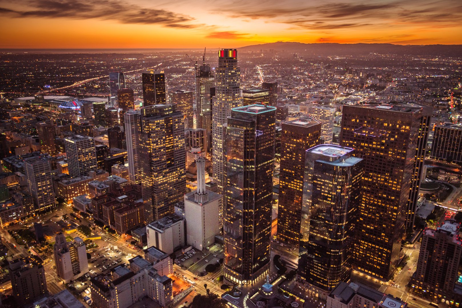 Aerial view of downtown Los Angeles skyscrapers at sunset.