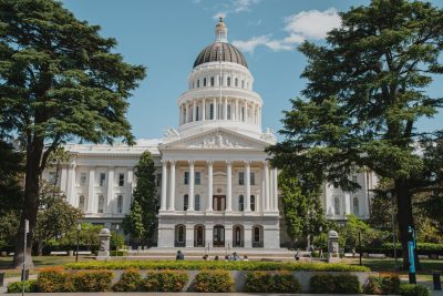 California State Capitol building in Sacramento with trees in front.