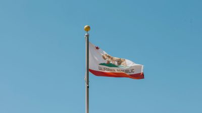 California Republic state flag waving against a clear blue sky.